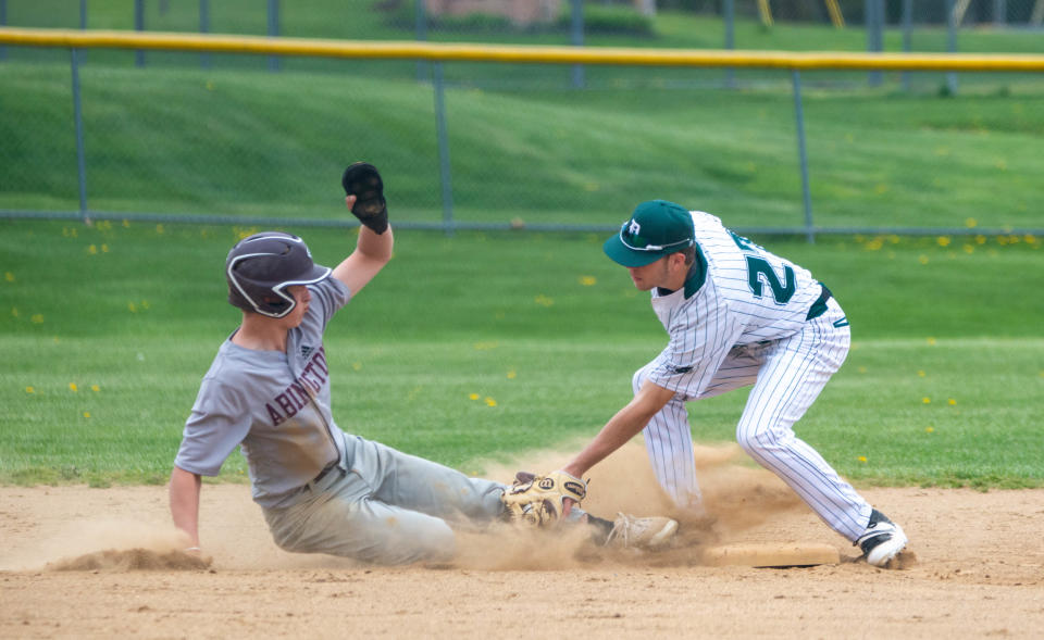 Dock’s Nate Lapp (27) puts the tag on a picked off Abington Chase Goodson (13) at second base in the second inning of the Abington at Dock Mennonite game Saturday, April 23, 2022 in Towamencin. Abington defeated Dock, 11-1, in the fifth inning due to the 10-run rule.