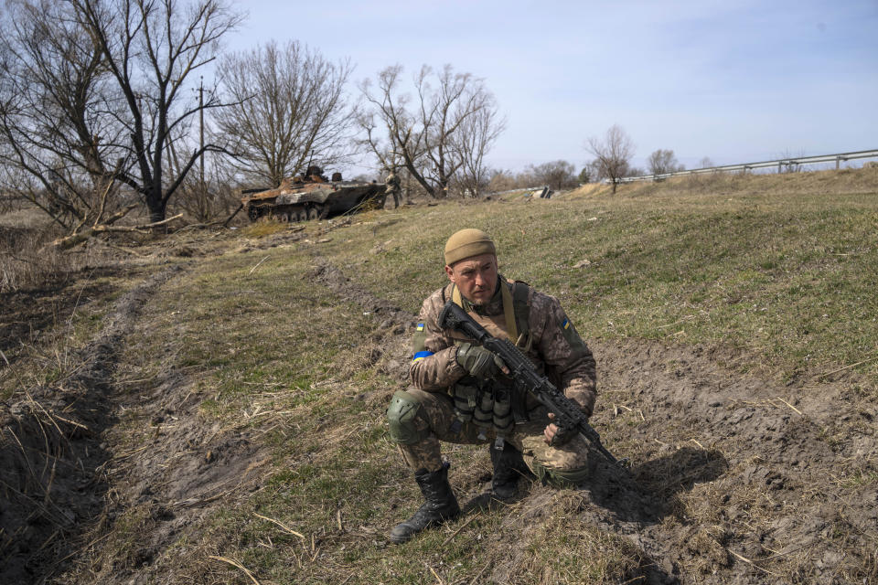 A Ukrainian soldier guards a position next to destroyed Russian tank near the front line in Brovary, on the outskirts of Kyiv, Ukraine, Monday, March 28, 2022. (AP Photo/Rodrigo Abd)
