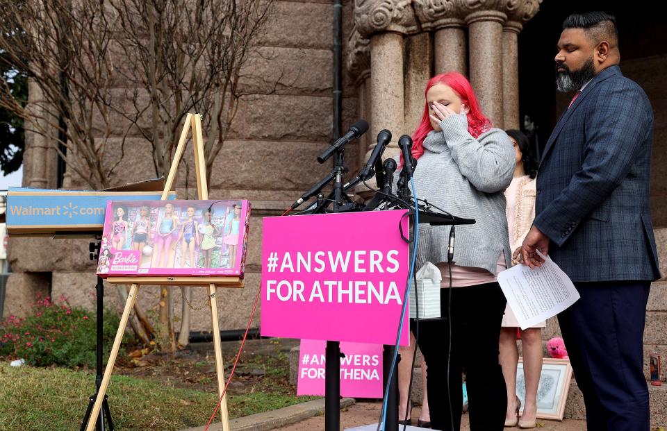 Maitlyn Gandy, mother of Athena Strand, wipes a tear while giving a press conference with attorney Benson Varghese, right, on Thursday at the Wise County Courthouse in Decatur, Texas. Gandy presented the box that was delivered on the day Strand, 7, was abducted, on left. Inside was a Christmas present for Strand.