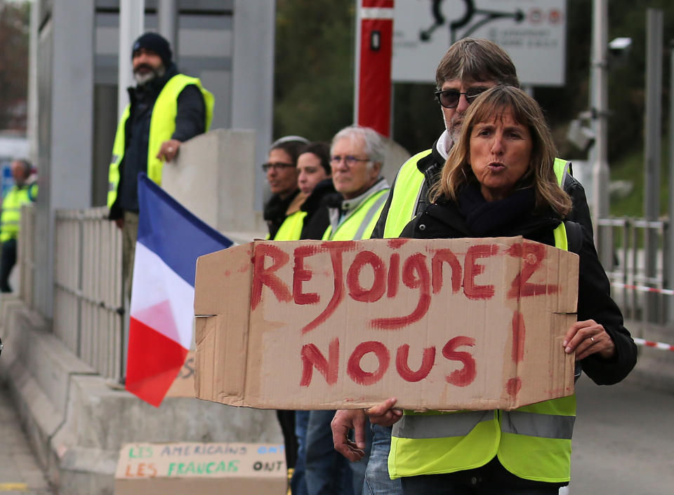 Una manifestante muestra un cartón con el lema "Únanse" durante una protesta en una autopista en Biarritz, en el suroeste de Francia, el 5 de diciembre de 2018. (AP Foto/Bob Edme)