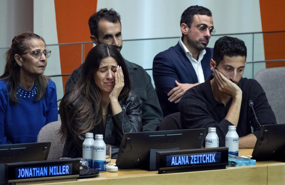 Rachel Zeitchik, left, Alana Zeitchik, center, and Liam Zeitchik, far right, along with other family members, come together to talk about their loved ones kidnapped by Hamas, members of the Cunio/Alony family, during an event at U.N. headquarters, Oct. 13, 2023. / Credit: Craig Ruttle / AP