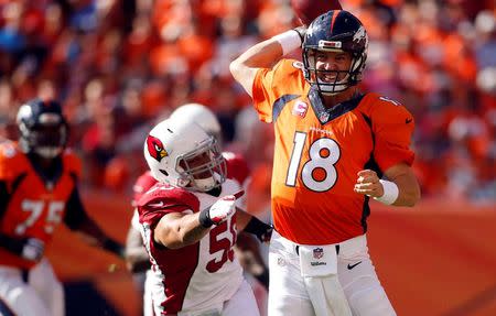 Oct 5, 2014; Denver, CO, USA; Denver Broncos quarterback Peyton Manning (18) throws the ball during the first half against the Arizona Cardinals at Sports Authority Field at Mile High. Mandatory Credit: Chris Humphreys-USA TODAY Sports