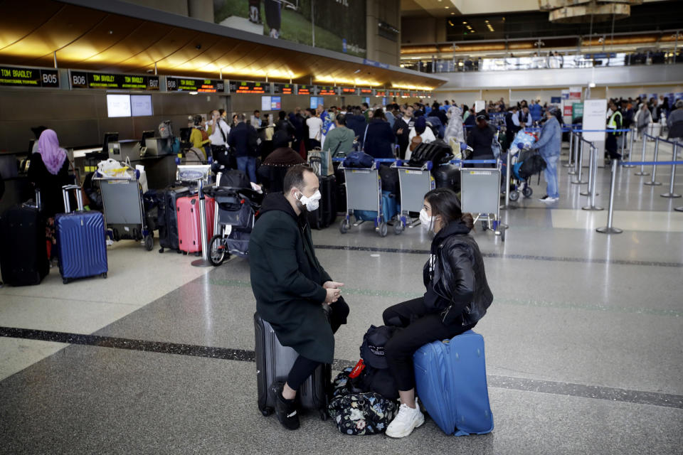 Image: People wait to check in their luggage at Los Angeles International Airport on March 14, 2020. (Marcio Jose Sanchez / AP)