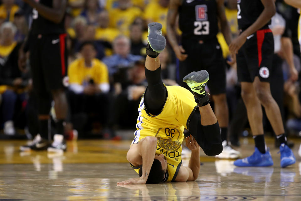 OAKLAND, CALIFORNIA:  Stephen Curry #30 de los Golden State Warriors gira sobre su espalda después de recibir una falta en el Juego 2 de la primera ronda de los playoffs de la NBA de 2019 en la Conferencia del Oeste en la ORACLE Arena el 15 de abril en Oakland, California. (Foto de Ezra Shaw/Getty Images)