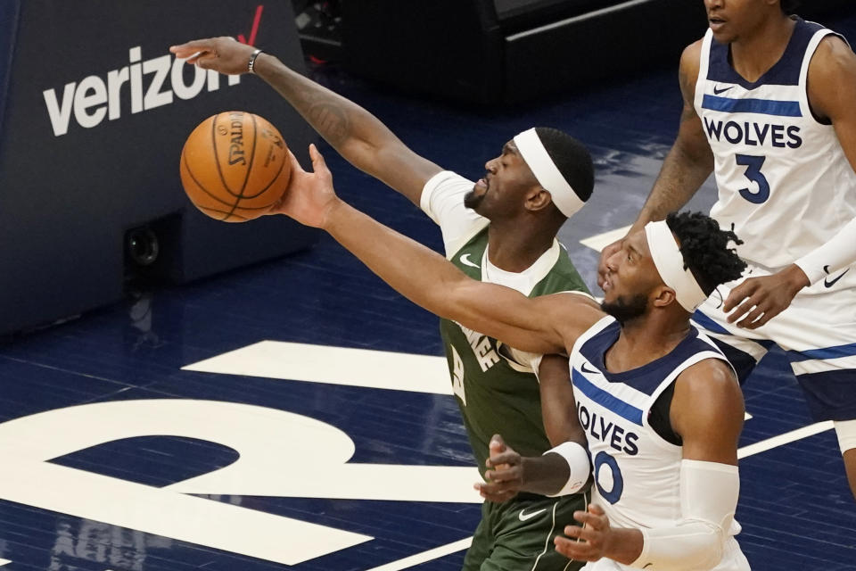 Minnesota Timberwolves' Josh Okogie, right, breaks up a shot attempt by Milwaukee Bucks' Bobby Portis in the first half of an NBA basketball game Wednesday, April 14, 2021, in Minneapolis. (AP Photo/Jim Mone)