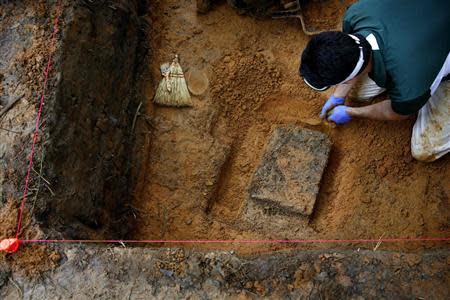 University of South Florida associate professor Christian Wells attempts to cut loose a block of dirt and clay containing skeletal remains in a grave at the now closed Arthur G. Dozier School for Boys in Marianna, Florida, September 2, 2013. REUTERS/Edmund D. Fountain/Pool