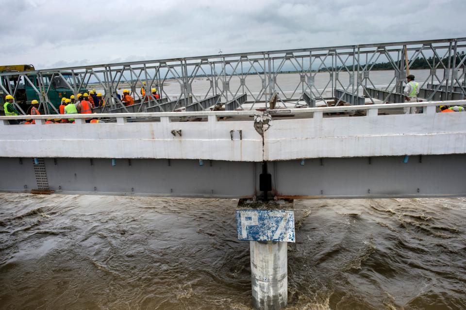 <p>Laborers work to restore a flood-damaged bridge on the outskirts of capital Naypyidaw in Myanmar on Aug. 30, 2018. (Photo: Ye Aung Thu/AFP/Getty Images) </p>