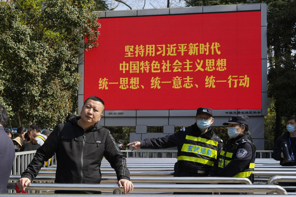 Security guard control access into the Mausoleum of Sun Yat-sen near a propaganda slogan promoting the era of Chinese President Xi Jinping during a visit by former Taiwan President Ma Ying-jeou, in Nanjing, in eastern China's Jiangsu province, Tuesday, March 28, 2023. Ma has departed for a tour of China in what he calls an attempt to reduce tensions a day after Taiwan lost one of its few remaining diplomatic partners to China. (AP Photo/Ng Han Guan)