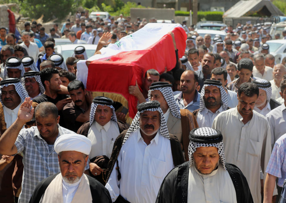 Mourners chant slogans against the al-Qaida breakaway group Islamic State of Iraq and the Levant (ISIL), while carrying a flag-draped coffin of Ammar Tueni, 24, a policeman killed in a car bomb attack during his funeral procession in Hillah, about 60 miles (95 kilometers) south of Baghdad, Iraq, Thursday, April 24, 2014. The Shiite-dominated city of Hillah has seen sporadic violence recently. Last month, a suicide car bomber hit another checkpoint in same area, killing 36 people. Iraq has seen a spike in violence since last year, with the death toll climbing to its highest levels since the worst of the country's sectarian bloodletting between 2006 and 2008. The U.N. says 8,868 people were killed in 2013, and more than 1,400 people were killed in the first two months of this year. (AP Photo/Karim Kadim)