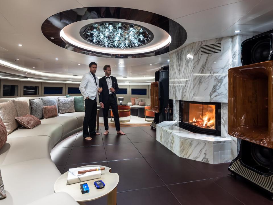 people by the wood burning fireplace of the Victorious superyacht
