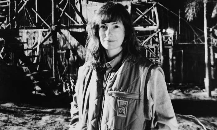 Woman in a jacket standing in front of scaffolding at night