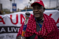 National coordinator of the Maa Unity Agenda group Jonathan Mpute ole Pasha, carries a ceremonial Maasai "Rungu" stick as he and other Maasai rights activists march towards the Tanzanian high commission in downtown Nairobi, Kenya Friday, June 17, 2022. Tanzania's government is accused of violently trying to evict Maasai herders from one of the country's most popular tourist destinations, the Ngorongoro Conservation Area. (AP Photo/Ben Curtis)