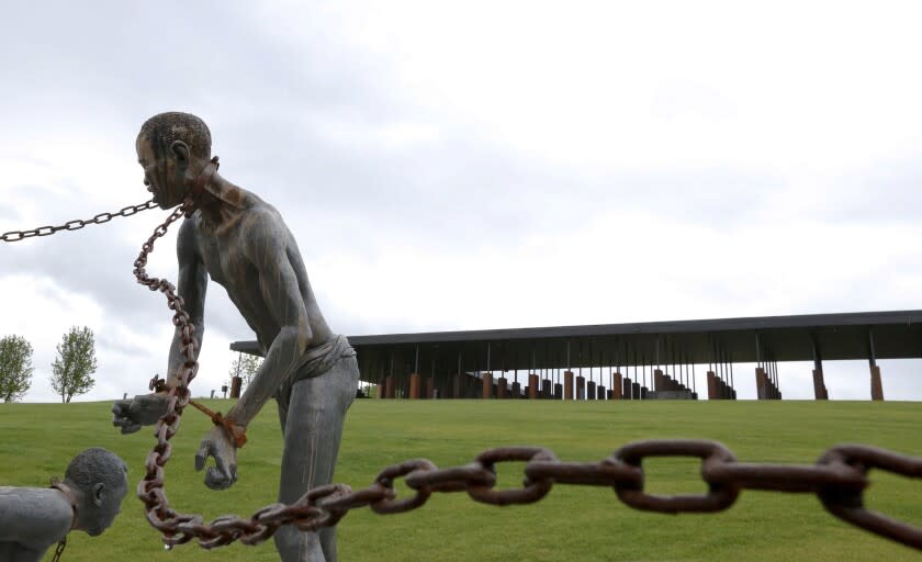 A statue of a chained man is on display at the National Memorial for Peace and Justice, a new memorial to honor thousands of people killed in racist lynchings, Sunday, April 22, 2018, in Montgomery, Ala. The national memorial aims to teach about America's past in hope of promoting understanding and healing. It's scheduled to open on Thursday. (AP Photo/Brynn Anderson)