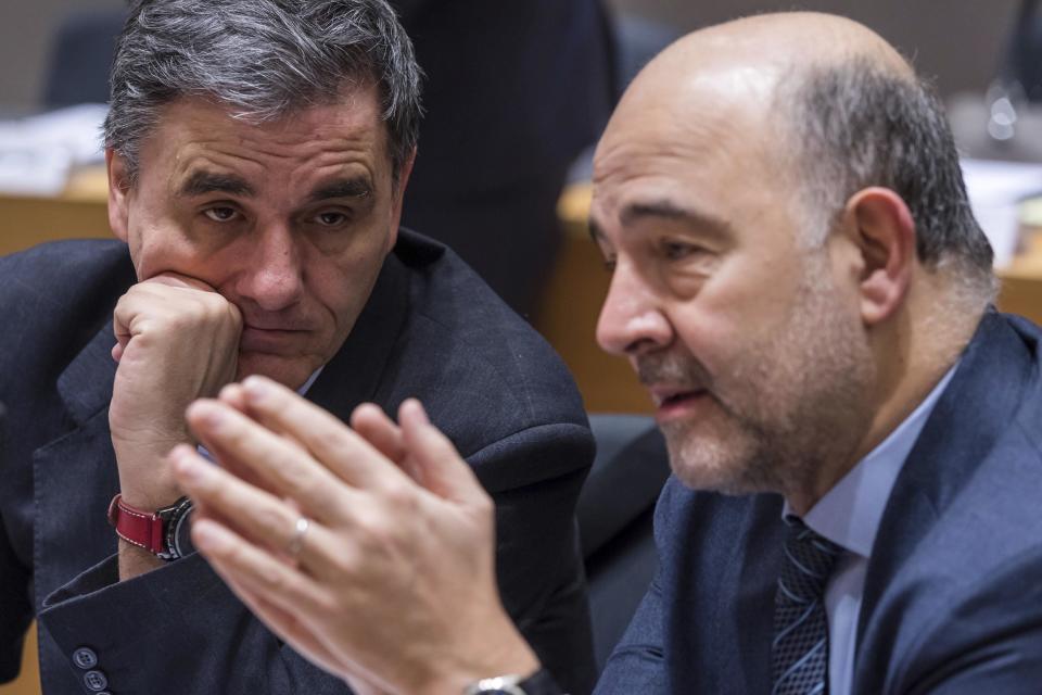 European Commissioner for Economic and Financial Affairs Pierre Moscovici, right, talks with Greece's Finance Minister Euclid Tsakalotos during a round table meeting of EU finance ministers at the EU Council building in Brussels on Friday, Jan. 27, 2017. (AP Photo/Geert Vanden Wijngaert)