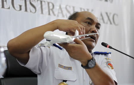 Soerjanto Tjahjono, the head of Indonesia's National Transportation and Safety Committee, holds a model plane during a news conference to announce the NTSC's findings in the investigation of the AirAsia QZ8501 crash, in Jakarta, Indonesia December 1, 2015. REUTERS/Garry Lotulung