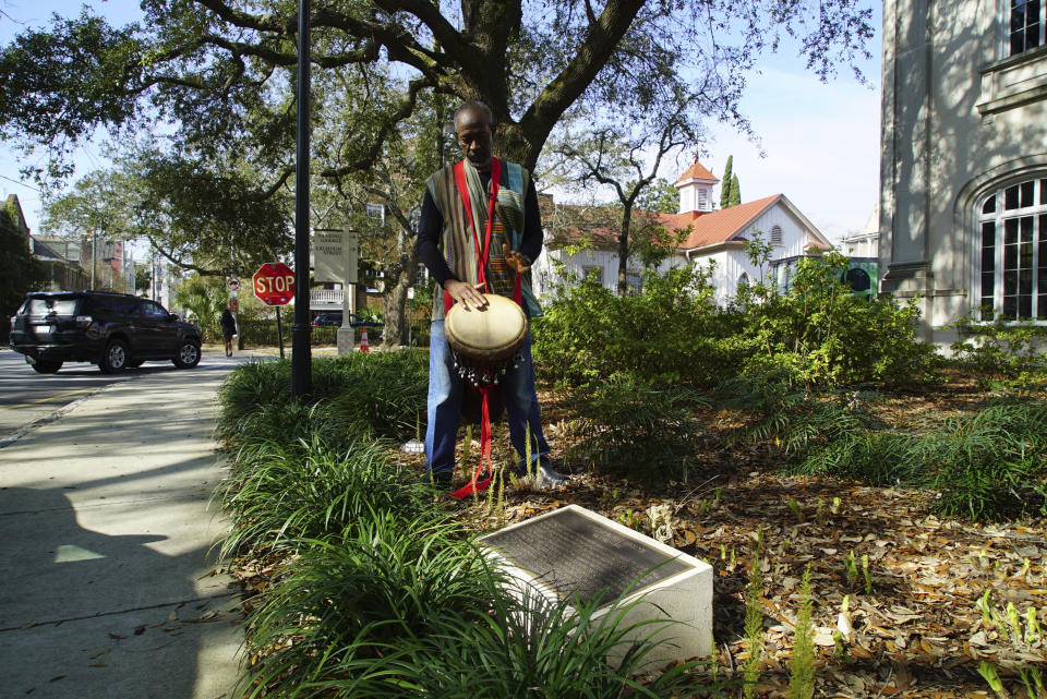 Ervin McDaniel Jr. plays his djembe, a West African drum, outside the Gaillard Performing Arts Center in Charleston, S.C., on Friday, Feb. 17, 2023. The retired city planner is among those whose hands will be cast in bronze as part of a memorial to the 36 likely enslaved people discovered in an unmarked burial ground at the Gaillard site. (AP Photo/Allen G. Breed)