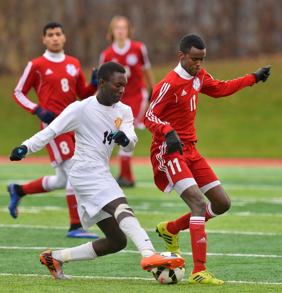 St. Cloud Apollo's Abdiaziz Handule (11) tries to block the progress of DeLaSalle's Christian Kardio (14) during the first half Thursday, Oct. 30 at Husky Stadium.