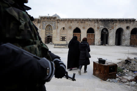 A Syrian army soldier stands guard as visitors walk inside Aleppo's Umayyad mosque, Syria January 31, 2017. REUTERS/Omar Sanadiki