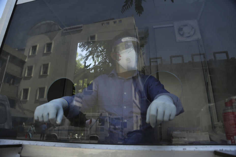 A health worker waits to take nasal swab samples for COVID-19 test at a government hospital in Jammu, India, Thursday, Oct.1, 2020. India is expected to become the pandemic's worst-hit country within weeks, surpassing the United States. (AP Photo/Channi Anand)