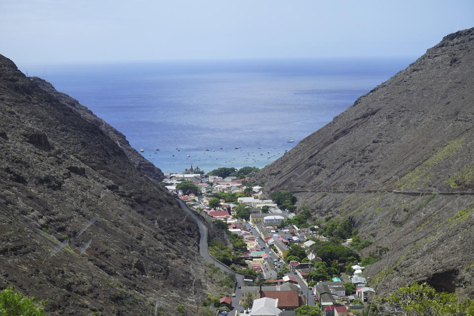 The city of Jamestown is pictured between massive volcanic cliffs on the remote island of St. Helena, Friday, Feb. 23, 2024. The quaint town is home to British Georgian-era colonial architecture, shops and restaurants. It’s also the main gathering place for the island’s festivals and celebrations. (AP Photo/Nicole Evatt)