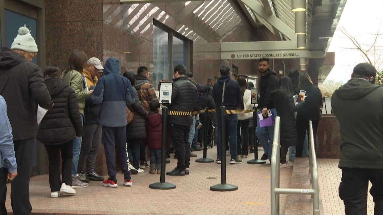 People line up outside the U.S. Consulate in Vancouver on Friday morning, as the U.S. State Department estimates nearly 2.5-year wait times for booking U.S. visitor visa interviews in the city. (CBC - image credit)