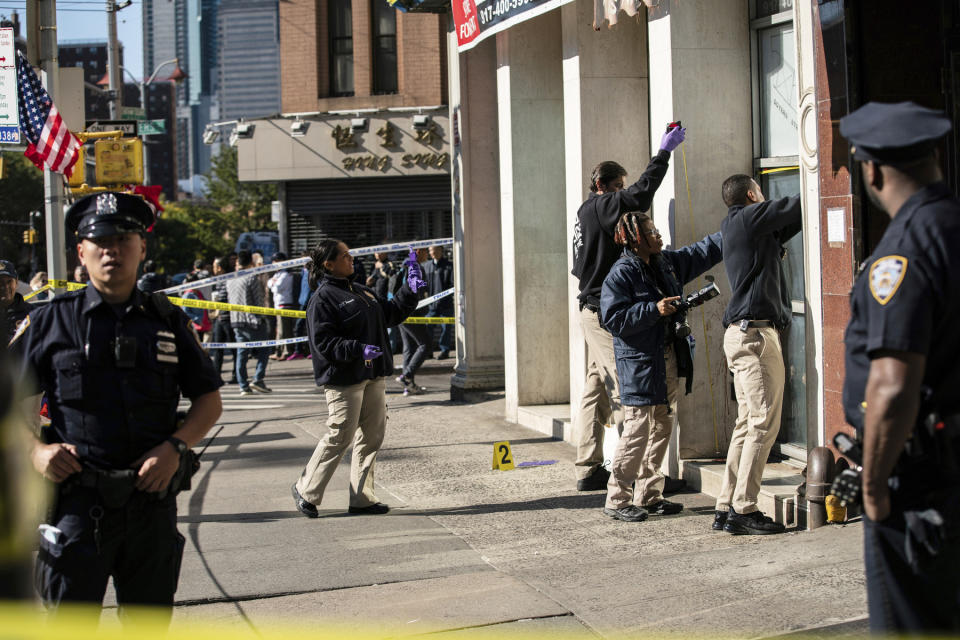 New York Police Department officers investigate the scene of an attack in Manhattan's Chinatown neighborhood, Saturday, Oct. 5, 2019 in New York. Four men who are believed to be homeless were attacked and killed early Saturday in a street rampage. NYPD Detective Annette Shelton said that a fifth man remained in critical condition after also being struck with a long metal object that authorities recovered. (AP Photo/Jeenah Moon)