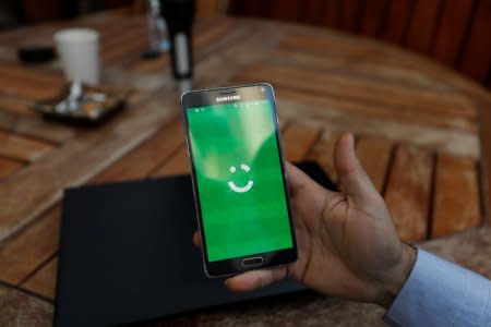 FILE PHOTO: An employee shows the logo of ride-hailing company Careem on his mobile in his office in the West Bank city of Ramallah July 17, 2017. REUTERS/Mohamad Torokman