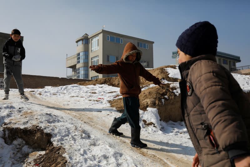 Afghan boys slide down a snow-covered slope in Kabul