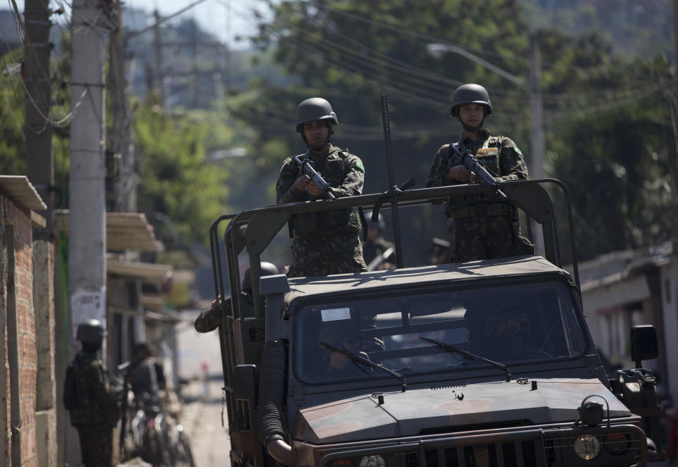 Soldiers patrol the Complexo de Alemao slum during an operation in Rio de Janeiro, Brazil, Monday, Aug. 20, 2018. At least 11 people have been killed during shootouts involving military personnel and police in Rio on Monday. Since February, the military has been in charge of security in the state of Rio de Janeiro, which is struggling to curb a spike in violence. (AP Photo/Silvia Izquierdo)