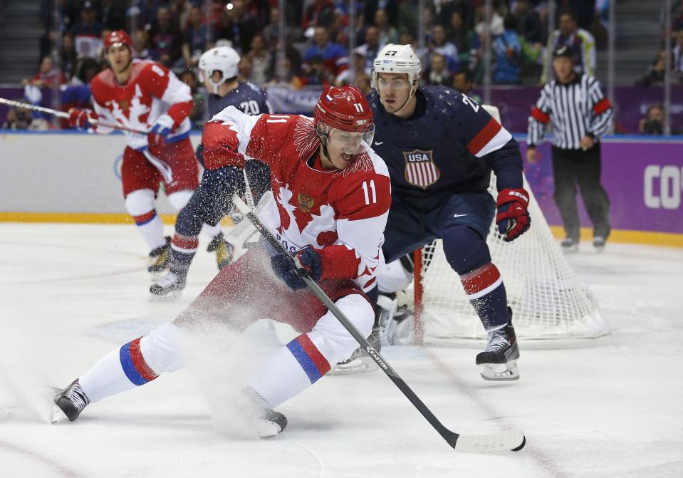 Russia's Yevgeni Malkin (L) spins away from Team USA's Ryan McDonagh during the first period of their men's preliminary round ice hockey game at the Sochi 2014 Winter Olympic Games February 15, 2014. REUTERS/Jim Young (RUSSIA - Tags: SPORT OLYMPICS SPORT ICE HOCKEY)