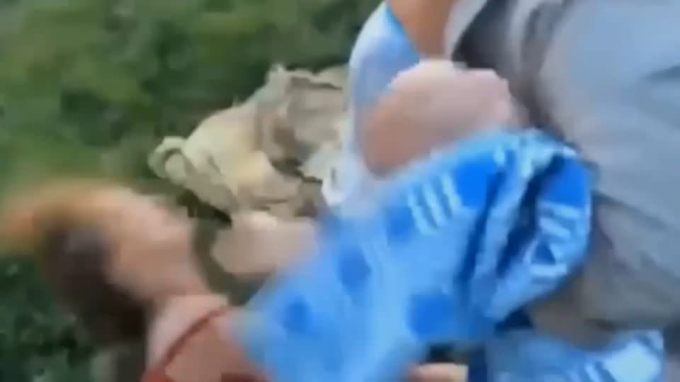 With a stranger holding her baby, the 'drunk' mother is hit in the face.