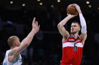 Washington Wizards center Kristaps Porzingis, right, shoots over Charlotte Hornets center Mason Plumlee during the first half of an NBA basketball game in Charlotte, N.C., Friday, Dec. 2, 2022. (AP Photo/Nell Redmond)