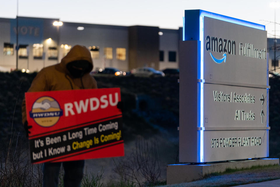 An RWDSU union rep holds a sign outside the Amazon fulfillment warehouse at the center of a unionization drive on March 29, 2021 in Bessemer, Alabama. Employees at the fulfillment center are currently voting on whether to form a union, a decision that could have national repercussions. / Credit: Elijah Nouvelage / Getty Images