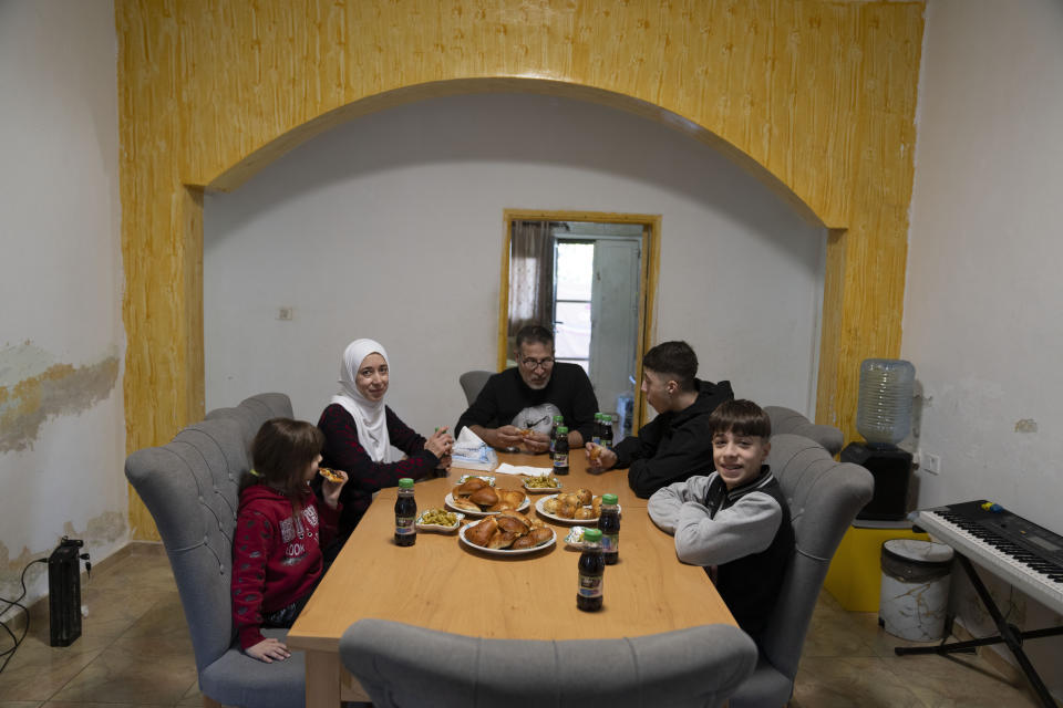 Palestinian Tamimi family gather for a meal with their son Wisam, 17 second right, a released prisoner under the Israel Hamas cease fire agreement last week, at the family house in the West Bank village of Nabi Saleh, northwest of Ramallah, Thursday, Nov. 30, 2023. The release of Palestinian prisoners under the Israel-Hamas cease-fire agreement last week has touched nearly everyone in the occupied West Bank, where 750,000 Palestinians have been arrested since 1967. In negotiations with Israel to free hostages in Hamas captivity in Gaza, the militant group has pushed for the release of high-profile prisoners. But experts say most Palestinians passing through Israel's ever-revolving prison door are young men arrested in the middle of the night for throwing stones and firebombs in villages near Israeli settlements. (AP Photo/Nasser Nasser)