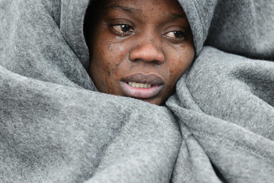 A migrant woman cries as she tries to warm herself upon the arrival of migrants at the village of Skala Sikaminias, on the Greek island of Lesbos, after crossing the Aegean sea from Turkey, Saturday, Feb. 29, 2020. Hundreds of refugees and migrants in Turkey have begun heading for the country's land and sea borders with Greece, buoyed by Turkish officials' statements indicating they will not be hindered from crossing the frontier to head into Europe. (AP Photo/Michael Varaklas)