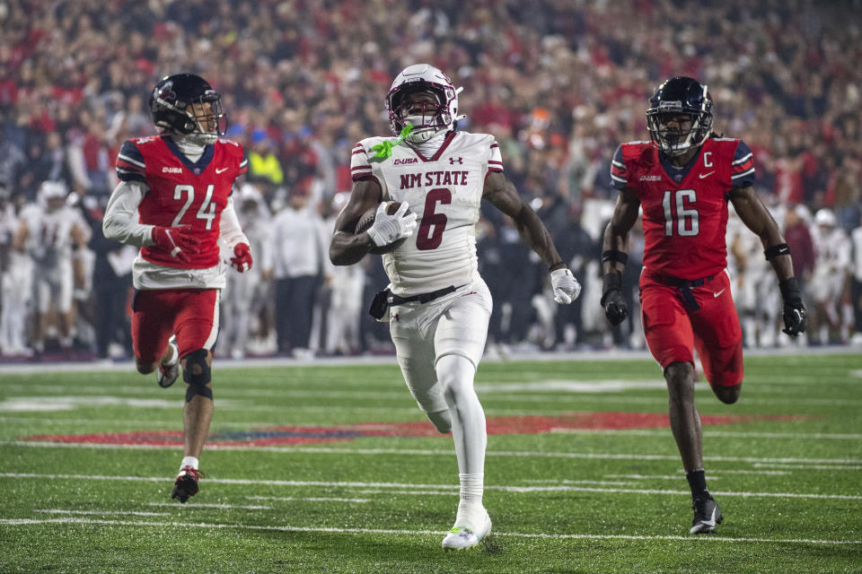 New Mexico State's Jonathan Brady runs for a touchdown past Liberty's Quinton Reese, right, and Preston Hodge during the second half of the Conference USA championship NCAA college football game Friday, Dec. 1, 2023, in Lynchburg, Va. (AP Photo/Robert Simmons)