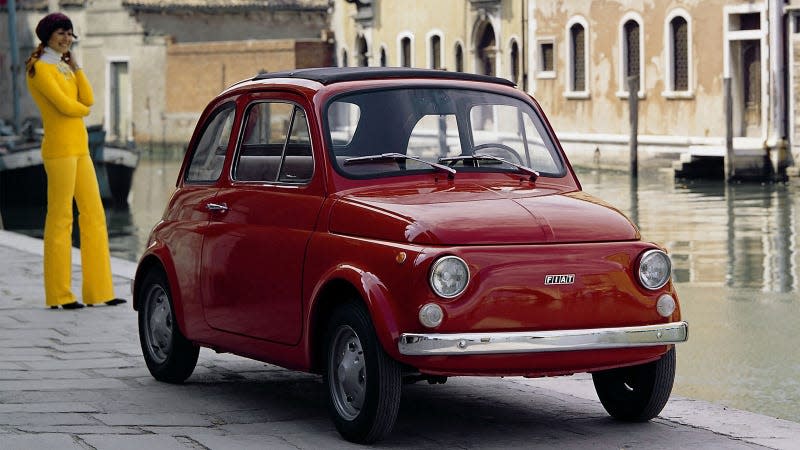 A photo of a red Fiat 500 small car. 