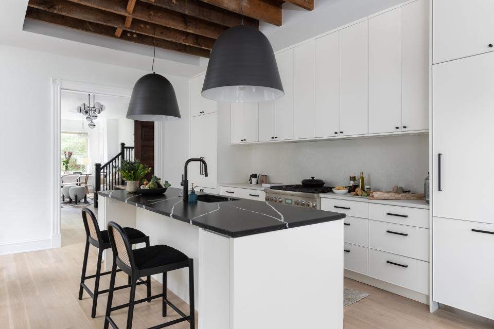 A modern kitchen with white countertops and matt black fixtures