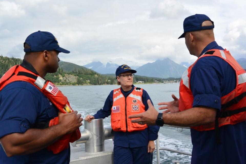 Vice Adm. Linda Fagan, Coast Guard Pacific Area commander, speaks with two Coast Guard officers while underway in Auke Bay, Alaska.