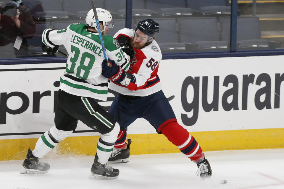 Dallas Stars' Joel L'Esperance, left, and Columbus Blue Jackets' David Savard compete for the puck during the first period of an NHL hockey game Tuesday, Feb. 2, 2021, in Columbus, Ohio. (AP Photo/Jay LaPrete)