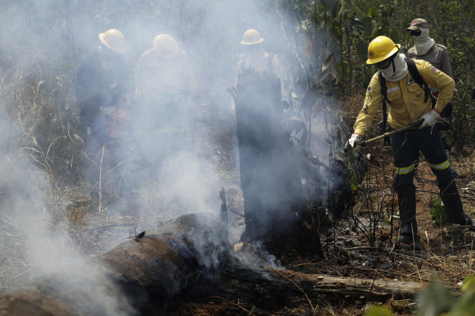 Firefighters put out fires in the Vila Nova Samuel region, along the road to Jacunda National Forest near the city of Porto Velho, Rondonia state, part of Brazil's Amazon, Sunday, Aug. 25, 2019. Leaders of the Group of Seven nations said Sunday they were preparing to help Brazil fight the fires burning across the Amazon rainforest and repair the damage even as tens of thousands of soldiers were being deployed to fight the blazes that have caused global alarm. (AP Photo/Eraldo Peres)