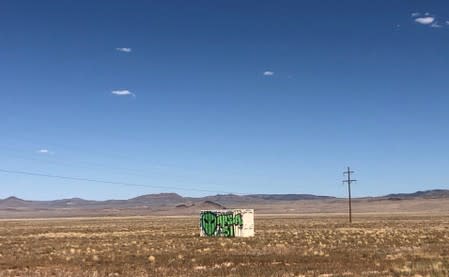 A shipping container with "Area 51" painted on its side sits in the desert in Rachel, Nevada