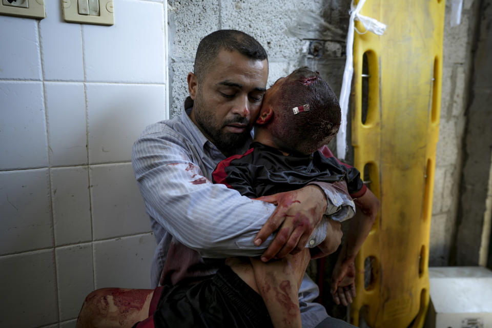 A Palestinian man holds the body of his child killed in the Israeli bombardment of the Gaza Strip, at a hospital morgue in Deir al-Balah, Tuesday, July 9, 2024. (AP Photo/Abdel Kareem Hana)