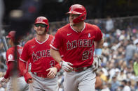 Los Angeles Angels' Mike Trout (27) and Taylor Ward (3) look on after scoring on Trout's home run off a pitch from Seattle Mariners starter Logan Gilbert during the fourth inning of a baseball game, June 19, 2022, in Seattle. (AP Photo/John Froschauer)