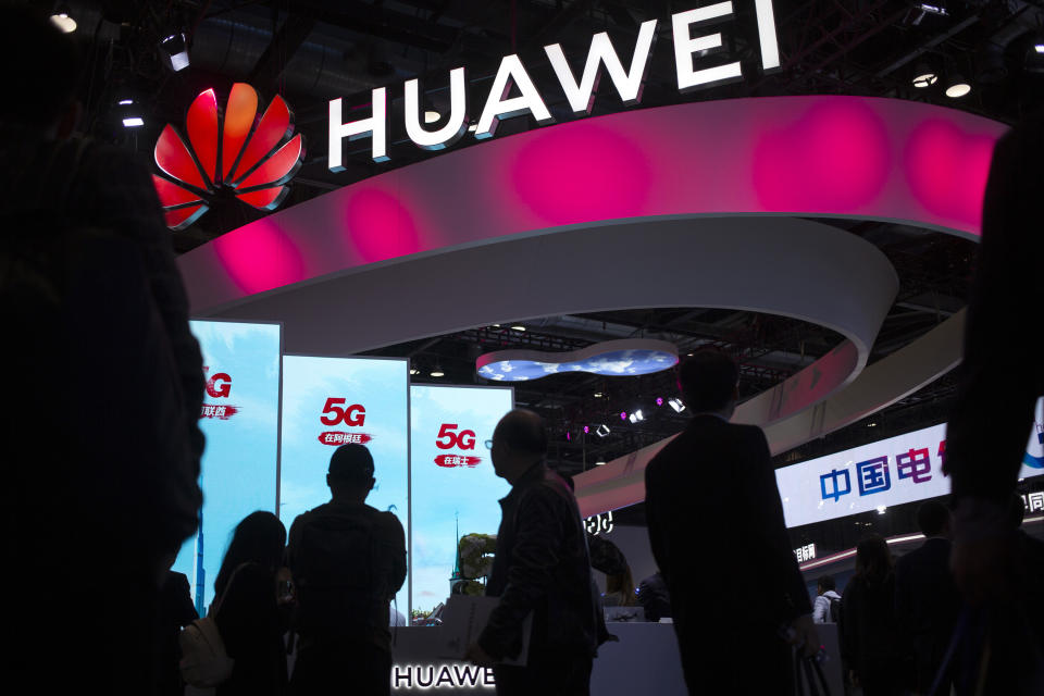 FILE - In this Oct. 31, 2019, file photo, attendees walk past a display for 5G services from Chinese technology firm Huawei at the PT Expo in Beijing. Chinese tech giant Huawei says its 2019 sales rose 19.1% over a year earlier despite U.S. sanctions that hampered its smartphone and network equipment businesses. (AP Photo/Mark Schiefelbein, File)