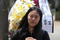 People pay their respects at the site where a man fell from a scaffolding at the Pacific Place complex while protesting against a proposed extradition bill, in Hong Kong