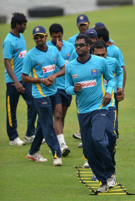 Sri Lanka cricket captain Angelo Mathews and teammates warm up during a practice session in Galle on August 3, 2014