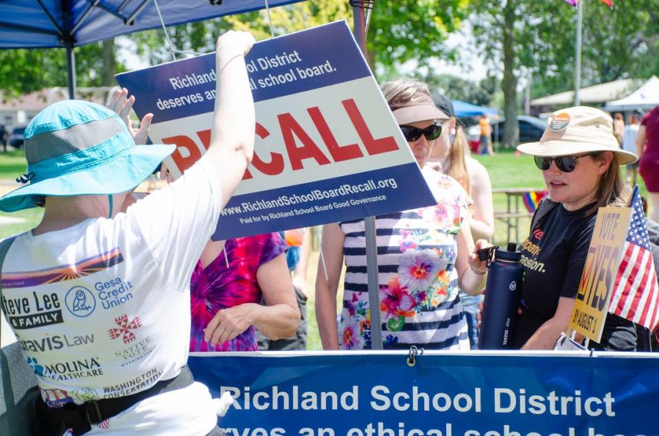 The Richland School Board Recall campaign group hands out signs Saturday, July 8, at the Tri-Pride gay pride festival in support of recall school board members Kari Williams, Audra Byrd and Semi Bird.
