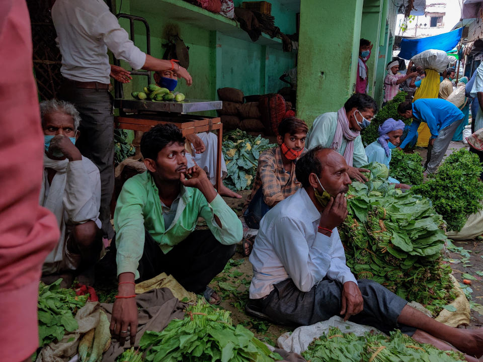 FILE- In this May 13, 2021 file photo, people sit at a vegetables market in Prayagraj, Uttar Pradesh, India. A dip in the number of coronavirus cases in Mumbai is offering a glimmer of hope for India, which is suffering through a surge of infections. (AP Photo/Rajesh Kumar Singh, File)