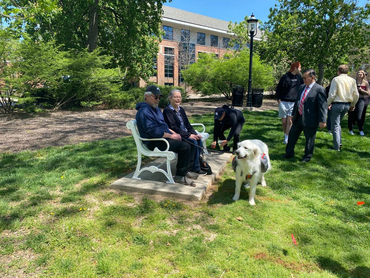 Cris and Linda Wood with Luna on a bench in Peace Park dedicated Friday to the memory of Harlan, the beloved Great Pyrenees that died in February at age 11. Luna is Harlan's niece, owned by Jason Furrer. MU chancellor and system president Mun Choi observes.